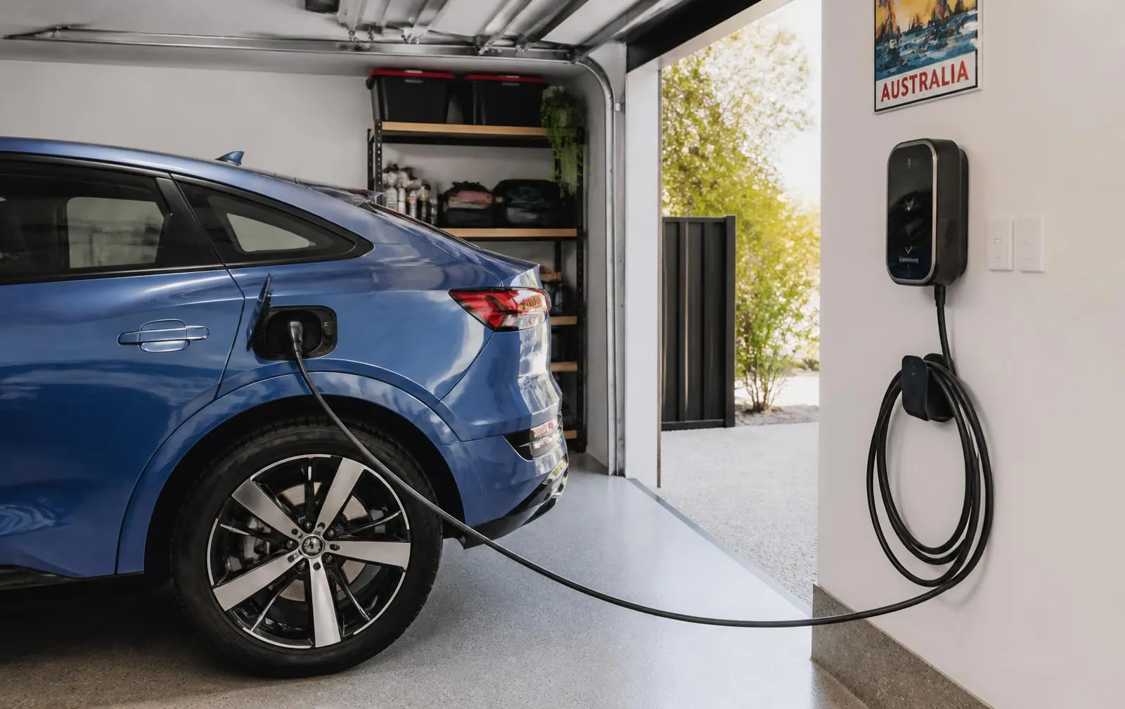 Electric SUV charging from a wall-mounted charger inside a modern Australian garage